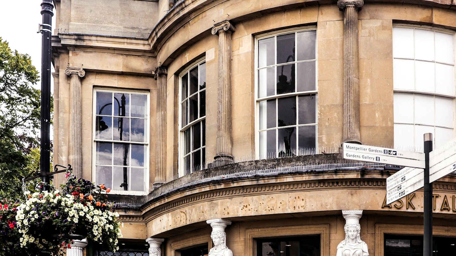 A bow-fronted Regency building in honey-coloured stone in Cheltenham town centre
