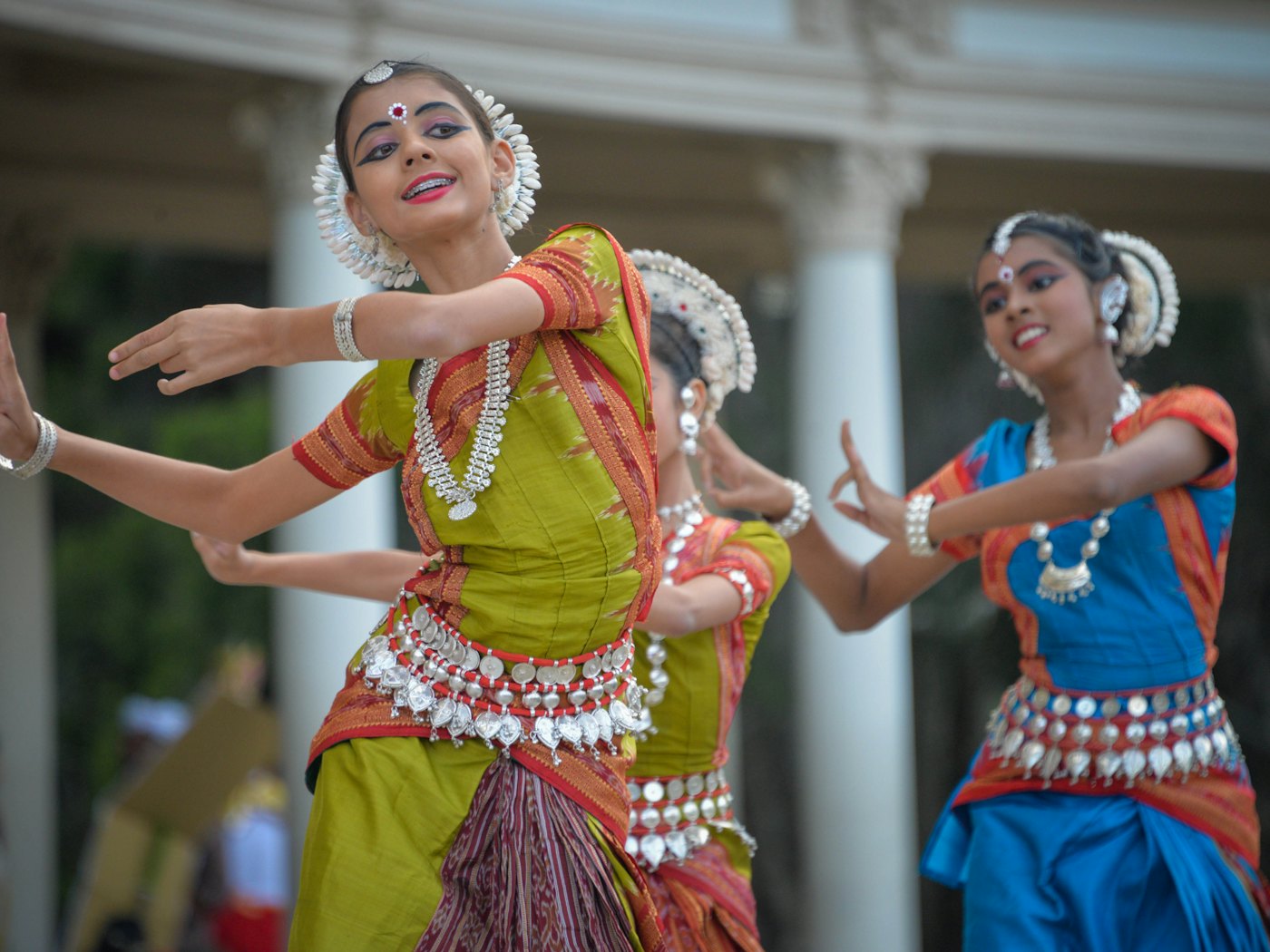 Two dancers in brightly coloured traditional Indian dress performing at a festival