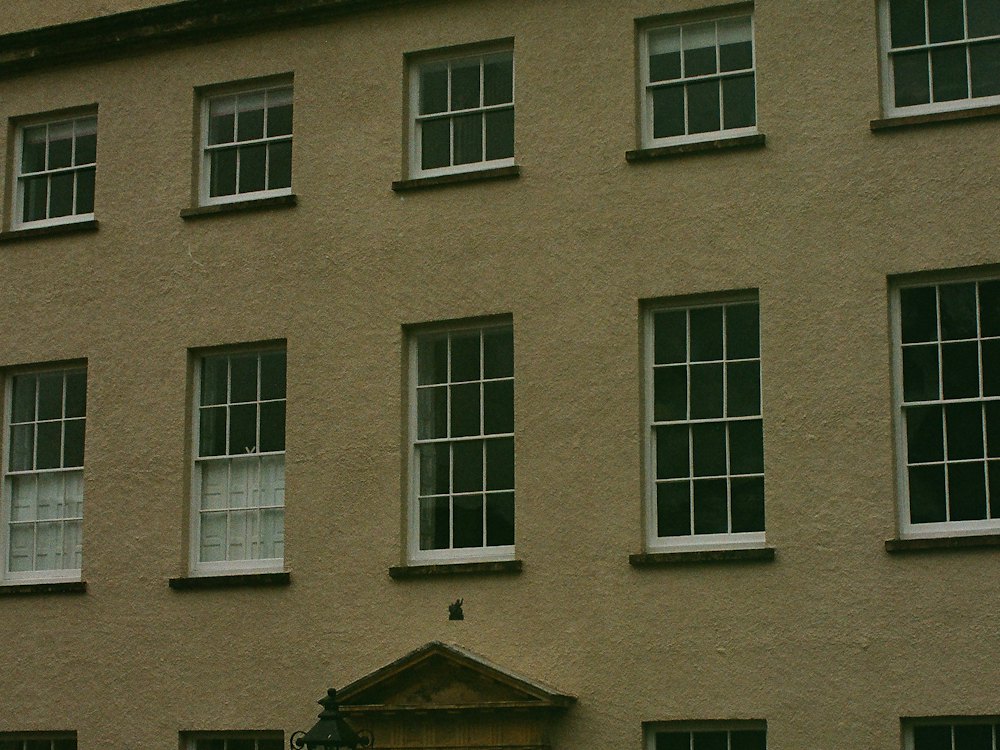 The brick front of a Georgian house with rows of white sash windows