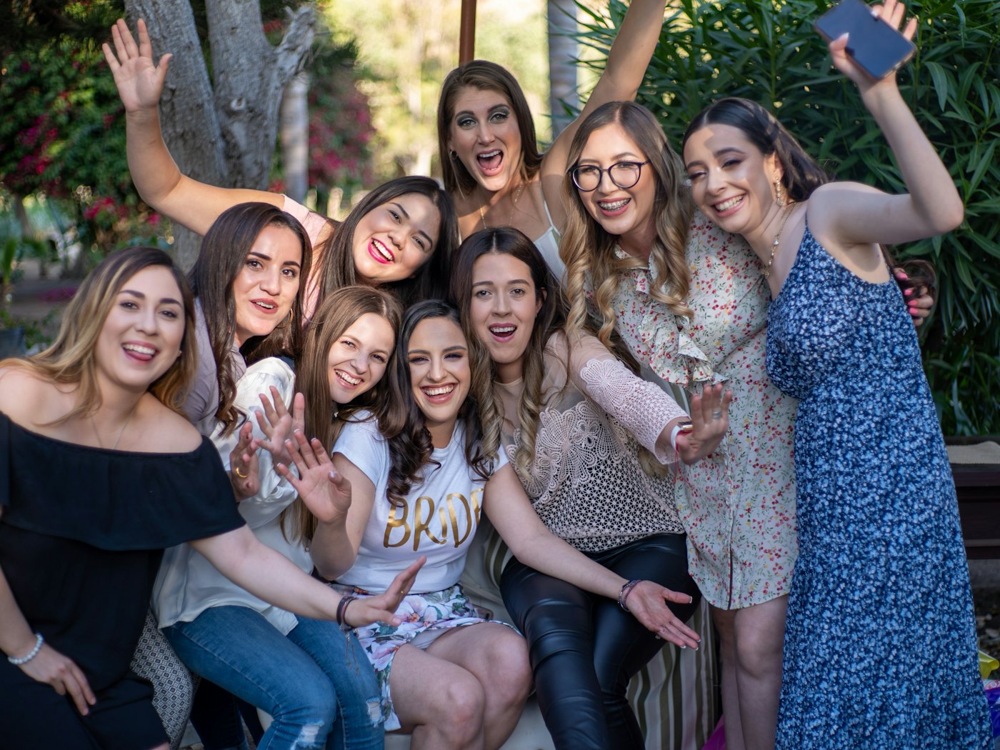 A group of friends cheering and waving together at a reunion